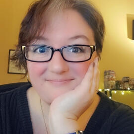 A woman with brown hair and glasses smiling